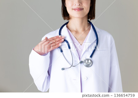 Middle-aged female doctor in a white coat Middle-aged female doctor in a white coat 136654759