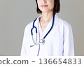 Middle-aged female doctor in a white coat 136654833