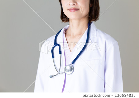 Middle-aged female doctor in a white coat Middle-aged female doctor in a white coat 136654833