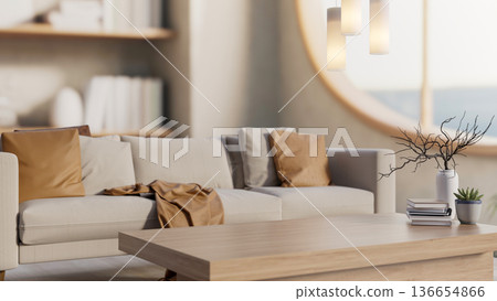 Books and potted plant on wooden table and sofa couch aside round window with lamp in a living room Books and potted plant on wooden table and sofa couch aside round window with lamp in a living room 136654866