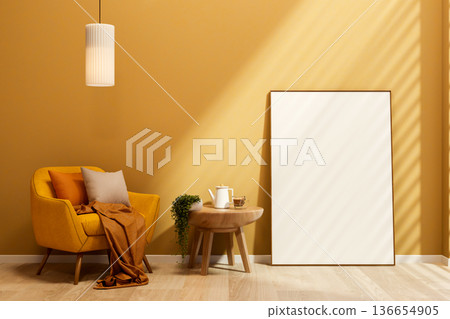 Yellow sofa chair under hanging lamp and coffee on side table with white frame leaning against wall. Yellow sofa chair under hanging lamp and coffee on side table with white frame leaning against wall. 136654905