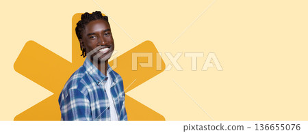 A man with braided hair smiles while wearing a plaid shirt. He stands against a light yellow background with a large graphic shape. The setting gives a vibrant and lively feel. A man with braided hair smiles while wearing a plaid shirt. He stands against a light yellow background with a large graphic shape. The setting gives a vibrant and lively feel. 136655076