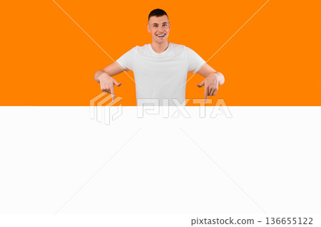 Great Offer. Cheerful Man Pointing Fingers At Empty Paper Board Advertising Your Text Standing Over Yellow Studio Background, Smiling To Camera. Look There Concept. Mockup Great Offer. Cheerful Man Pointing Fingers At Empty Paper Board Advertising Your Text Standing Over Yellow Studio Background, Smiling To Camera. Look There Concept. Mockup 136655122