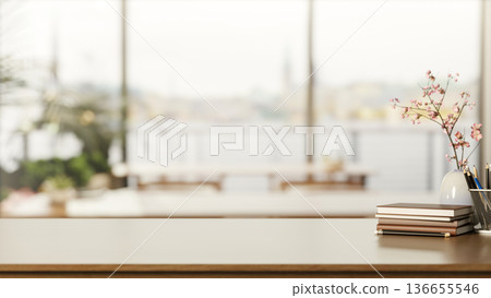 Books and pencil aside flower vase on wooden counter table across window wall in living room or cafe 136655546