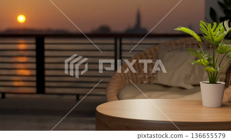 Potted plant on round wooden table and woven sofa chair at balcony or rooftop and sunset above river Potted plant on round wooden table and woven sofa chair at balcony or rooftop and sunset above river 136655579