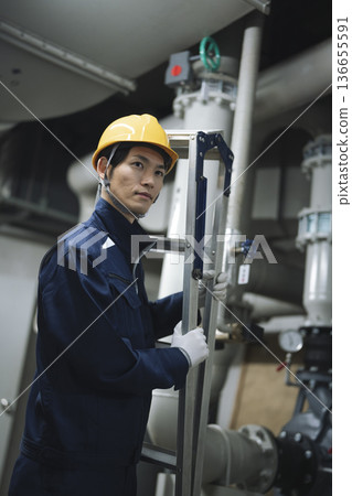 在樓宇設備機房工作的工人 在樓宇設備機房工作的工人 136655591