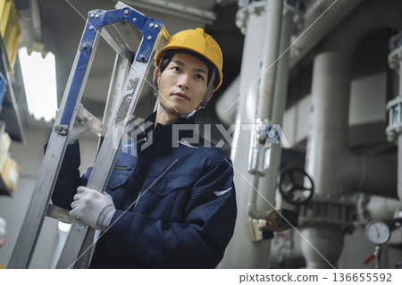 在樓宇設備機房工作的工人 136655592