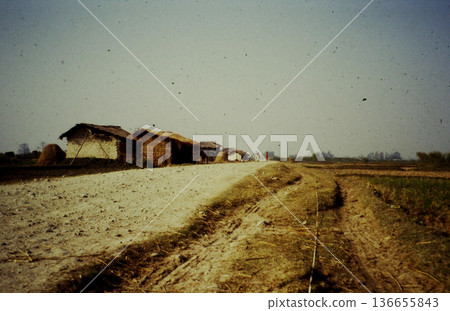 A scene of life in rural Nepal, with thatched houses, farm roads, and fields (photographed in 1989, editorial) A scene of life in rural Nepal, with thatched houses, farm roads, and fields (photographed in 1989, editorial) 136655843