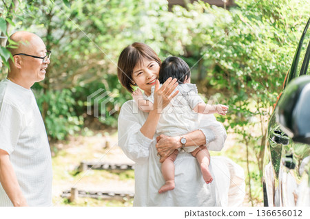 一對老年夫婦抱著他們的孫子(回家,第一個孫子,回家,父母回家) 一對老年夫婦抱著他們的孫子(回家,第一個孫子,回家,父母回家) 136656012