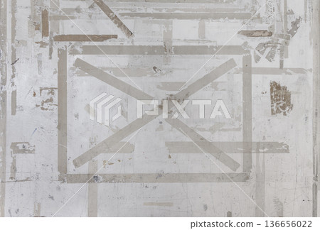 Grunge texture of a concrete wall with remnants of adhesive tape 136656022