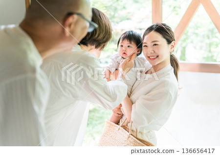 一位母親抱著回到父母家的孫女（返鄉，三代同堂） 136656417