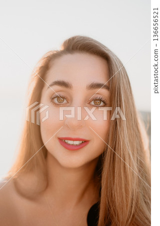 Woman smiling portrait Close up portrait of a young woman smiling outdoors during golden hour sunset light Woman smiling portrait Close up portrait of a young woman smiling outdoors during golden hour sunset light 136656521