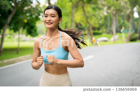 Young runner Asian woman jogging in park path, skinny fit in sports wear outfit leggings and top Young runner Asian woman jogging in park path, skinny fit in sports wear outfit leggings and top 136656909