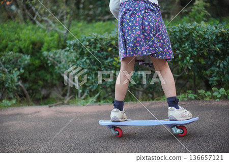 The feet of a child riding a skateboard in the park 136657121