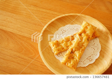 Photo of baked pie stick snacks on a wooden plate Photo of baked pie stick snacks on a wooden plate 136657481