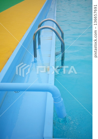 Outdoor pool ladder and clear blue water Outdoor pool ladder and clear blue water 136657691