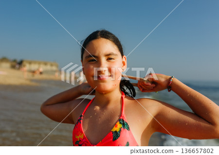 portrait of a teenage girl standing on the beach portrait of a teenage girl standing on the beach 136657802