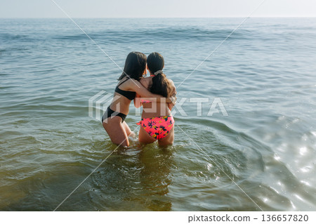 rear view of two girls going to swim in the sea 136657820