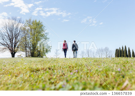 rear view of two persons walking in the park rear view of two persons walking in the park 136657839
