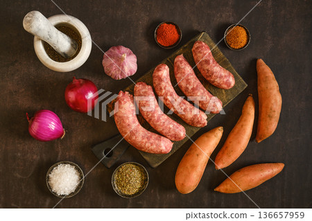 Natural casing sausages ready for cooking with ingredients on a wooden board Natural casing sausages ready for cooking with ingredients on a wooden board 136657959