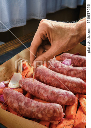 Natural casing sausages being prepared with vegetables in a cozy kitchen setting 136657966