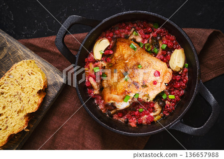 Cooking chicken in a pot with vegetables and bread on a wooden board 136657988