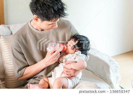 Father feeding his baby with a bottle (childcare, parental leave, parental leave, child rearing) Father feeding his baby with a bottle (childcare, parental leave, parental leave, child rearing) 136658347