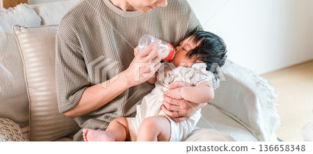 Father feeding his baby with a bottle (childcare, parental leave, parental leave, child rearing) 136658348