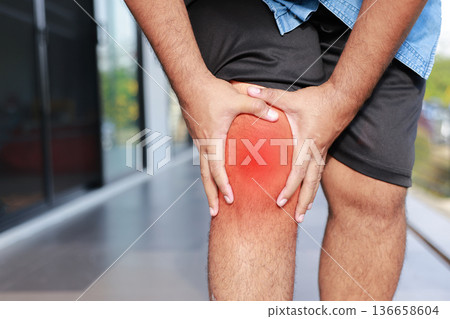 Asian man suffering from severe knee pain with red inflamed area. Concept of osteoarthritis, meniscus injury, gout, rheumatoid arthritis, and orthopedic medical treatment in adult patients. Asian man suffering from severe knee pain with red inflamed area. Concept of osteoarthritis, meniscus injury, gout, rheumatoid arthritis, and orthopedic medical treatment in adult patients. 136658604