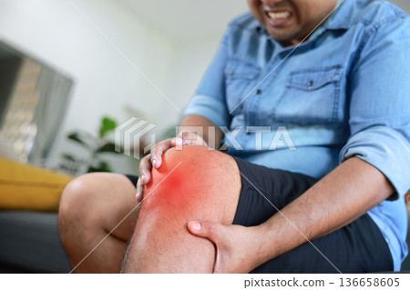 Asian man suffering from severe knee pain with red inflamed area. Concept of osteoarthritis, meniscus injury, gout, rheumatoid arthritis, and orthopedic medical treatment in adult patients. Asian man suffering from severe knee pain with red inflamed area. Concept of osteoarthritis, meniscus injury, gout, rheumatoid arthritis, and orthopedic medical treatment in adult patients. 136658605