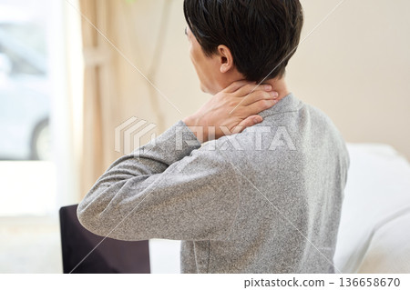 Asian man with a sore neck touching his hand Asian man with a sore neck touching his hand 136658670