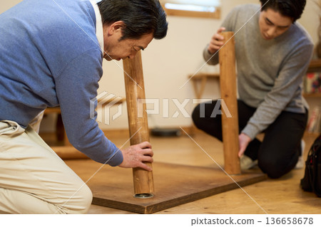 一名亞洲男子正在組裝一張自製桌子 136658678