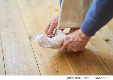 Senior Asian man putting on socks 136658680