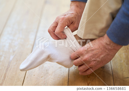 一位年長的亞洲男子正在穿襪子 136658681