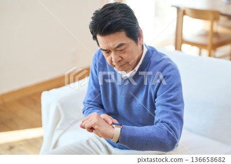 Senior Asian man managing his health with a smartwatch Senior Asian man managing his health with a smartwatch 136658682