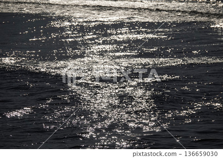 The water surface sparkles with the reflection of the setting sun The water surface sparkles with the reflection of the setting sun 136659030