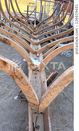 Closeup Of Vessel Assembly With Curved Timber Joinery Focus. Detailed View Of Shipbuilding Process Showing Precise Timber Fitting And Support Securing In Drydock 136659481