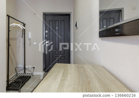 Modern Home Entrance with Wooden Console Table and Black Door 136660216