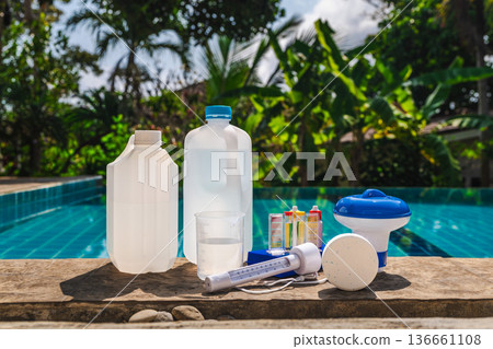 Pool water testing accessories arranged on pool edge, including chemical containers, test tubes, thermometer, floating dispenser and chlorine tablet Pool water testing accessories arranged on pool edge, including chemical containers, test tubes, thermometer, floating dispenser and chlorine tablet 136661108