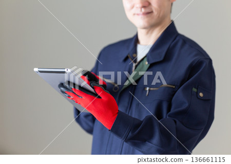Middle-aged male businessman in work clothes holding a tablet Middle-aged male businessman in work clothes holding a tablet 136661115