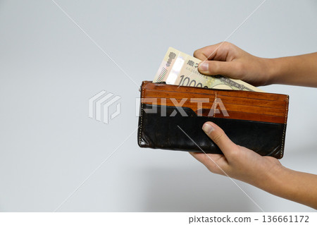 Close-up of a hand taking out a 10,000 yen bill from a wallet Close-up of a hand taking out a 10,000 yen bill from a wallet 136661172