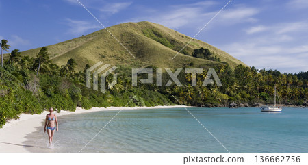 Girl in a bikini walking along a tropical beach in Fiji in South Pacific 136662756