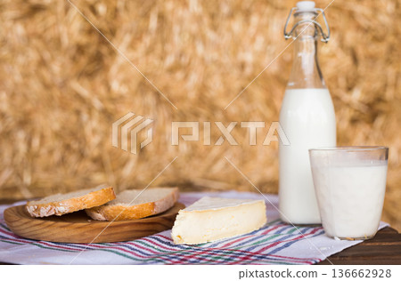 Rustic breakfast of milk, fresh wheat bread and brie in the haylof Rustic breakfast of milk, fresh wheat bread and brie in the haylof 136662928