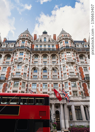 Classic British architecture lines a traditional London street, with red brick buildings and historic facades beneath a cloudy sky. 136663407
