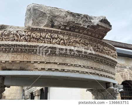 Ancient stone architecture with detailed carvings under cloudy sky 136663751