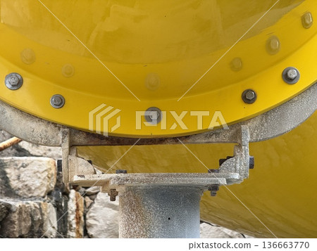 Yellow industrial pipe close-up with visible bolts and textured metal surface for use as background Yellow industrial pipe close-up with visible bolts and textured metal surface for use as background 136663770