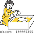 Woman putting clothes into a box 136665355