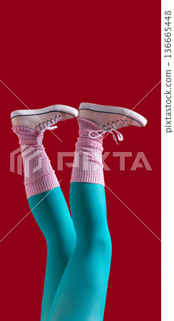 Female legs in teal tights pink leg warmers and white sneakers on red background Female legs in teal tights pink leg warmers and white sneakers on red background 136665448