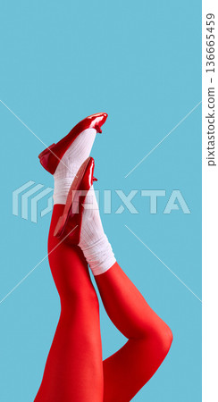 Female legs in red tights and red patent shoes on blue background. 136665459