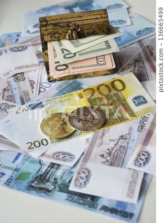 Bitcoin, a chest of dollars, and a euro banknote in Russian rubles. Bitcoin, a chest of dollars, and a euro banknote in Russian rubles. 136665499